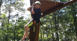 Boy being lowered off of ropes course