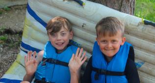 Two boys in life jackets at the camp waterfront